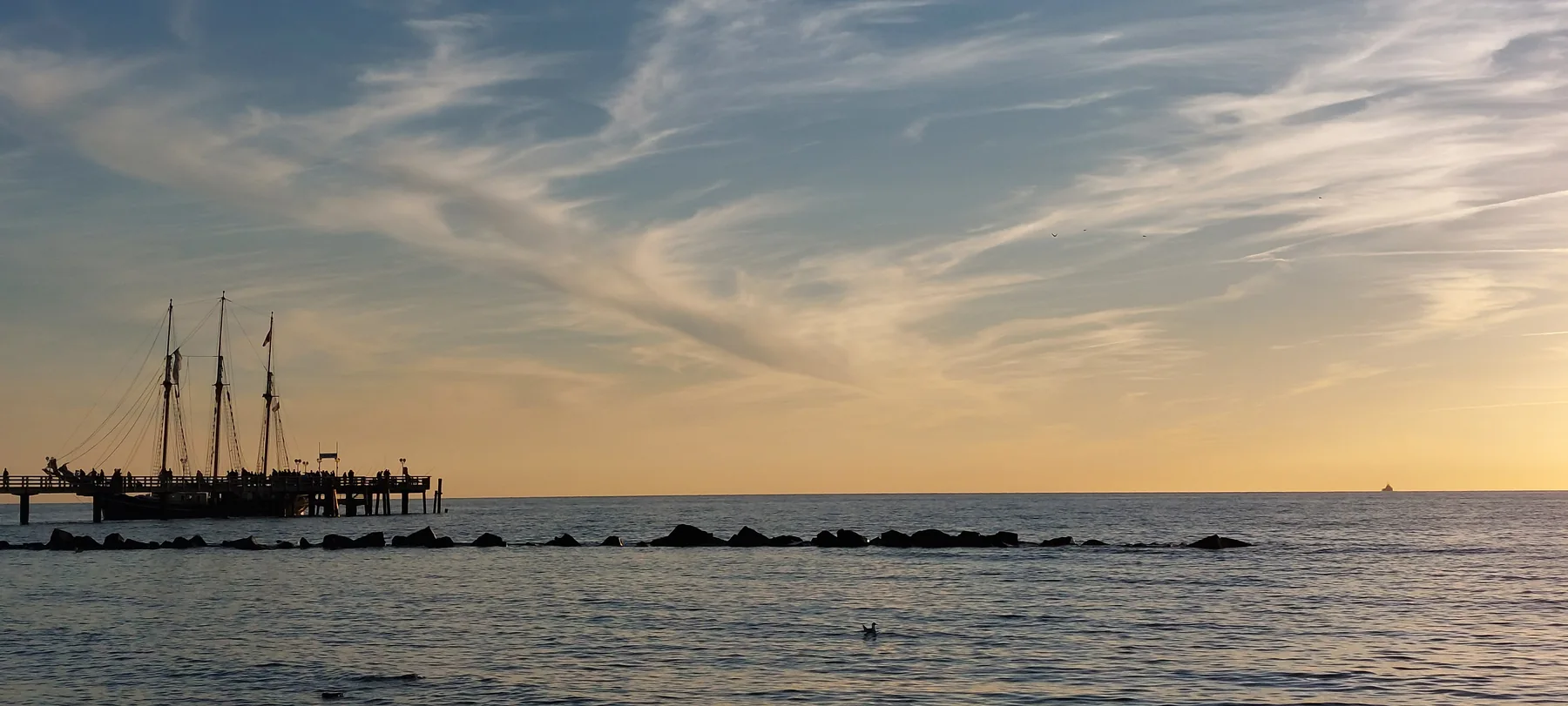 Segelschiff an der Seebrücke im Abendlicht