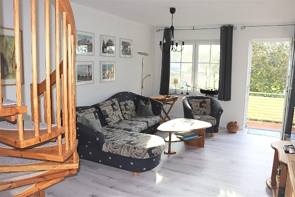 Wohnzimmer mit Sitzecke und Zugang zum Balkon
